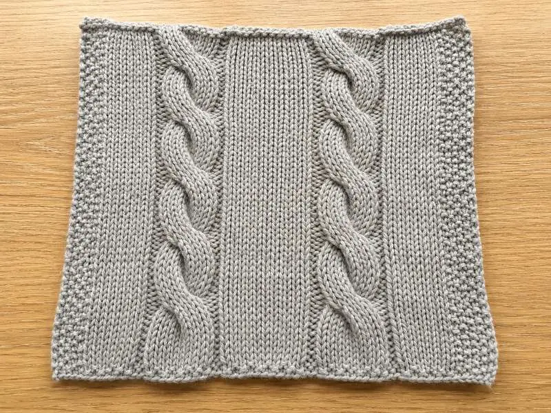 A single cable panel repeat — the number of needles per repeat must divide evenly into the total usable needle count for the panel to tile correctly at bulk.